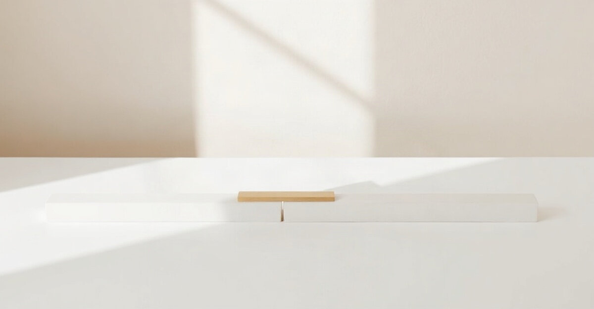 Two white bars laid end to end on a white table, with a small brass plate bridging the gap between them